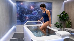Person cautiously entering a modern cold plunge tub, illustrating mental health benefits and safety.